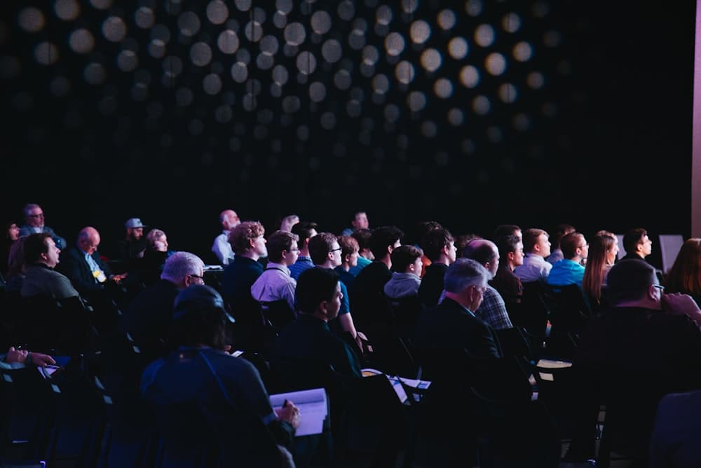 An audience watching a talk in a dark room