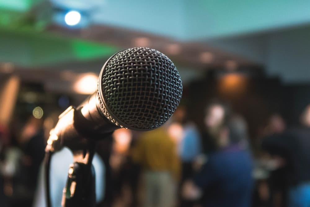 A microphone in front of a blurred audience