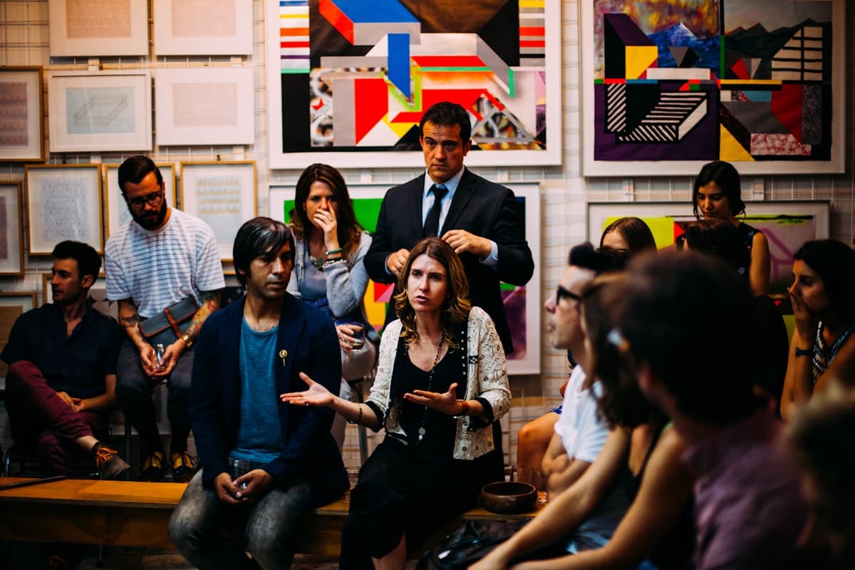 A meetup crowd in conversation at a gallery space